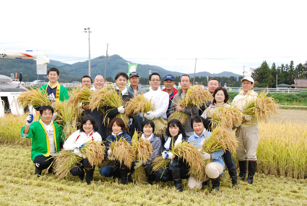刈り取った稲を手に、参加者全員で記念撮影